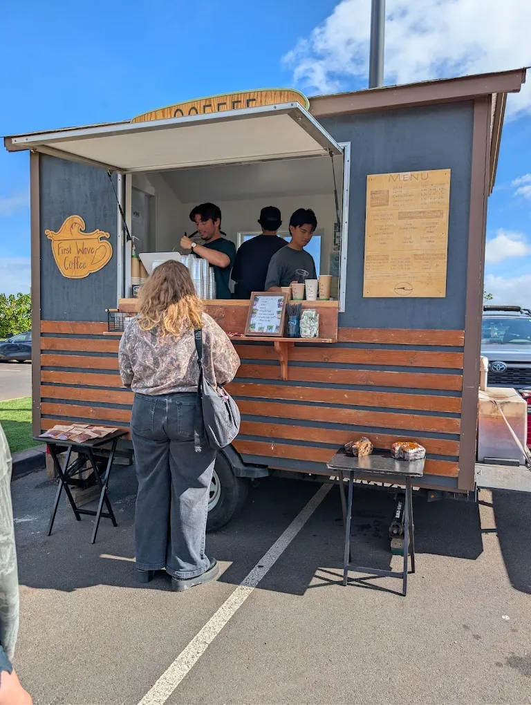 A customer being served at the First Wave Coffee trailer window.