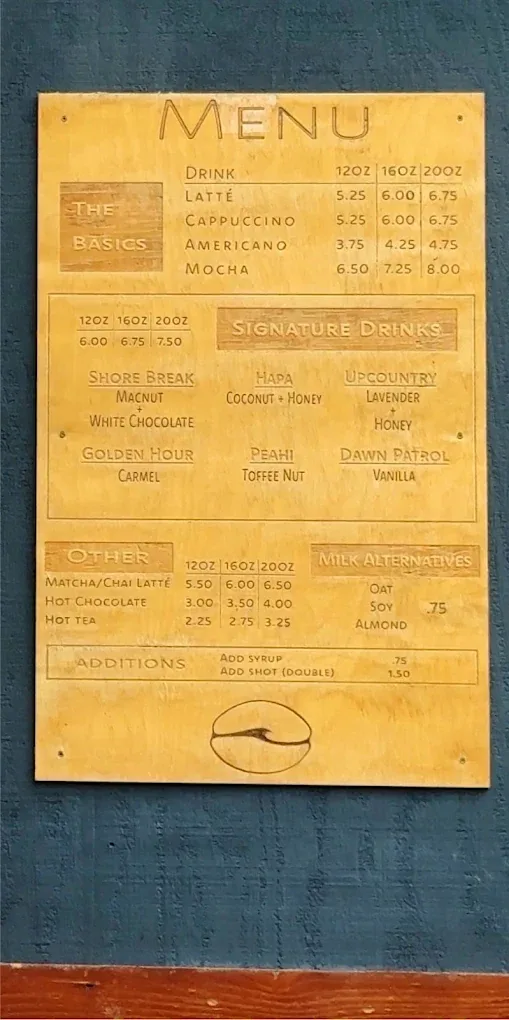 First Wave Coffee's hand-carved wooden menu board listing the basics and signature drinks.